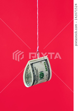 One hundred dollar bill on fishing hook over red background One hundred dollar bill on fishing hook over red background 142071524