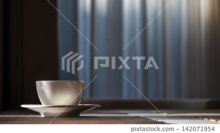 a morning hot coffee in white cup in sunshine scene with shade and white smoke from hot water a morning hot coffee in white cup in sunshine scene with shade and white smoke from hot water 142071954