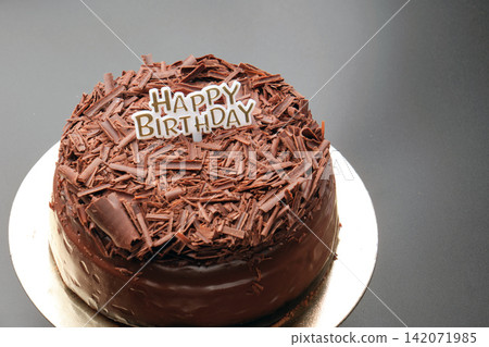 A dark black forest chocolate cake with a Happy Birthday sign sits on a black background A dark black forest chocolate cake with a Happy Birthday sign sits on a black background 142071985