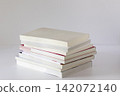 Neat Stack of Textbooks on White Surface Minimal Side View 142072140