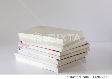 Neat Stack of Textbooks on White Surface Minimal Side View Neat Stack of Textbooks on White Surface Minimal Side View 142072140