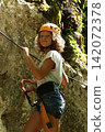 Young Girl Climbing on Rock in Adventure Gear 142072378