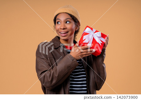 Happy Teen Girl Got Gift Box On Beige Background. Young Woman Smiling, Surprise Happy Teen Girl Got Gift Box On Beige Background. Young Woman Smiling, Surprise 142073900