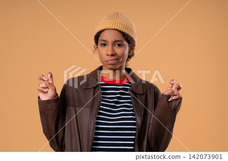 African American teenage girl making air quotes with fingers while showing sarcastic facial African American teenage girl making air quotes with fingers while showing sarcastic facial 142073901