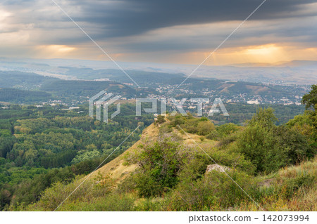 View of the mountains and Kislovodsk from the observation decks of the Kislovodsk Park. Evening sunset over the mountains of Kislovodsk. View of the mountains and Kislovodsk from the observation decks of the Kislovodsk Park. Evening sunset over the mountains of Kislovodsk. 142073994