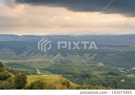 Layers of green mountains and hills in the haze during sunset. Panoramic View of Green hills and Meadow. Layers of green mountains and hills in the haze during sunset. Panoramic View of Green hills and Meadow. 142073995