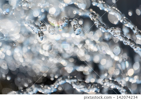 Splashes and jets of water against light background. Splashes and jets of water against light background. 142074234