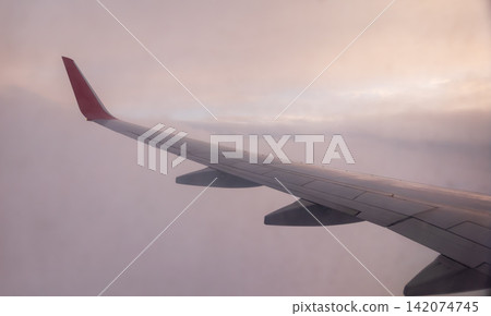 Beautiful salmon dawn and the wing of an airplane above the clouds. Beautiful salmon dawn and the wing of an airplane above the clouds. 142074745