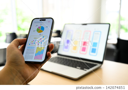 Checking graphs on a smartphone Checking graphs on a smartphone 142074851
