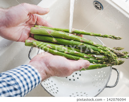 Male hands wash asparagus Male hands wash asparagus 142076094