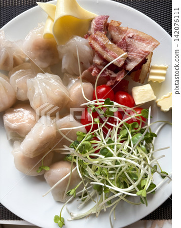 Plate with steamed dumplings and crispy bacon Plate with steamed dumplings and crispy bacon 142076111