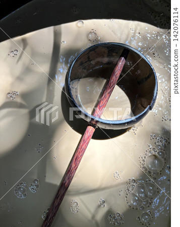 Wooden ladle in bubbling mineral mud bath Wooden ladle in bubbling mineral mud bath 142076114