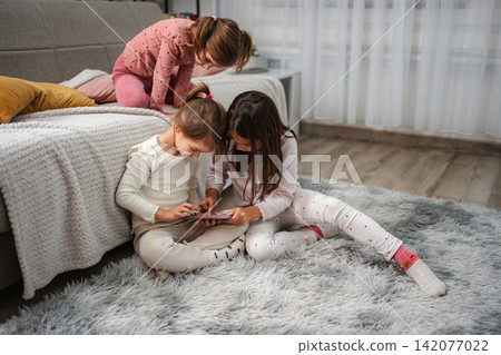 Children sharing digital tablet screen at home Children sharing digital tablet screen at home 142077022