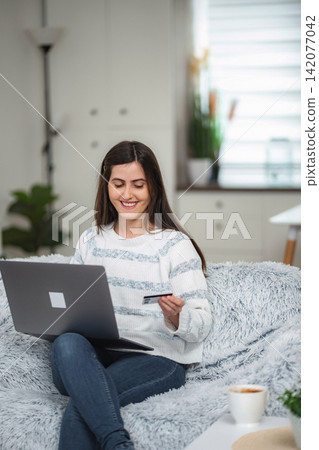 Young woman online shopping with laptop and credit card Young woman online shopping with laptop and credit card 142077042