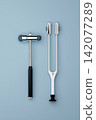 Neurological Reflex Hammer and Tuning Fork Set on Light Blue Background 142077289