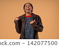 Happy african teen girl makes victory gesture YES, clenched fist, joy triumphant expression 142077500