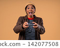 Pretty young Schoolgirl playing video exciting game on console with joystick isolated on beige 142077508