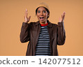 Amazed african woman expresses WOW. Impressed teen girl on beige. Great news. Concept of sales 142077512