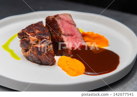Grilled beef steak served with sauce and pureed vegetables on a plate Grilled beef steak served with sauce and pureed vegetables on a plate 142077541