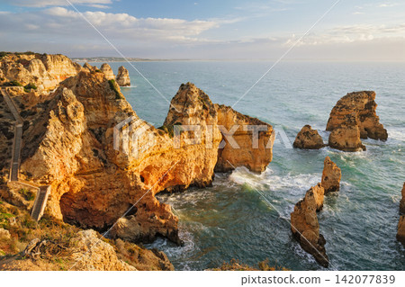 Ponte da Piedade sea stacks in Lagos, Algarve, Portugal, at sunrise with Atlantic ocean, cliffs, coastal rocks, and soft morning light Ponte da Piedade sea stacks in Lagos, Algarve, Portugal, at sunrise with Atlantic ocean, cliffs, coastal rocks, and soft morning light 142077839