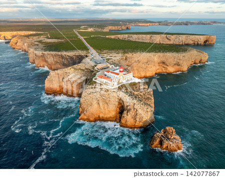Drone view of the Lighthouse of Cabo de Sao Vicente in Sagres, Algarve, Portugal, at sunset with open ocean and Atlantic ocean Drone view of the Lighthouse of Cabo de Sao Vicente in Sagres, Algarve, Portugal, at sunset with open ocean and Atlantic ocean 142077867