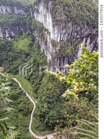 The breathtaking grandeur of the Wulong Karst National Geology Park in Chongqing, China, a sanctuary designated as a UNESCO World Natural Heritage Site. Sheer limestone cliffs rise monumentally from The breathtaking grandeur of the Wulong Karst National Geology Park in Chongqing, China, a sanctuary designated as a UNESCO World Natural Heritage Site. Sheer limestone cliffs rise monumentally from 142077914