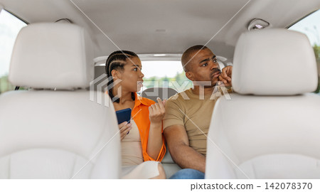 Young Black couple experiencing relationship tension inside car as the woman speaks Young Black couple experiencing relationship tension inside car as the woman speaks 142078370