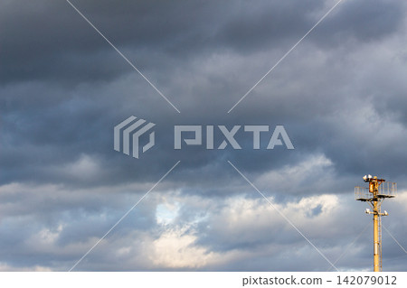Thick clouds and rooftop equipment spread across a summer evening (background image) Thick clouds and rooftop equipment spread across a summer evening (background image) 142079012