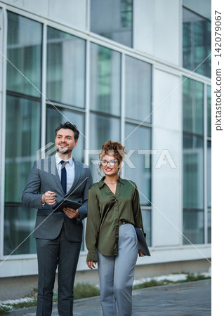 Business colleagues walking outdoors discussing future plans Business colleagues walking outdoors discussing future plans 142079067