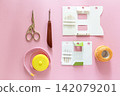 Sewing kit with scissors, seam ripper and thread spool on pink background 142079201