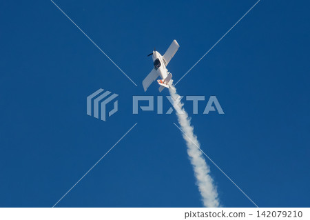 Stunt aerobatic plane performing stunts in air 142079210