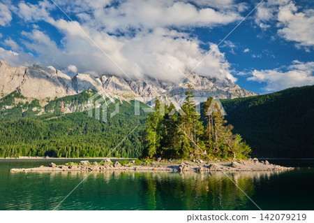 Small island on Eibsee lake with Zugspitze mountain range Bavaria Germany Small island on Eibsee lake with Zugspitze mountain range Bavaria Germany 142079219