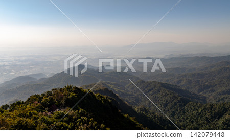 Scenic mountain landscape surrounding Doi Tung, Chiang Rai, with forested hills, distant valleys, and hazy mountain ranges. 142079448
