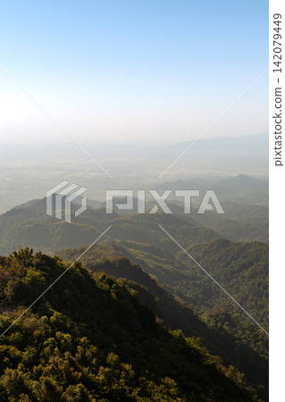Scenic mountain landscape surrounding Doi Tung, Chiang Rai, with forested hills, distant valleys, and hazy mountain ranges. 142079449