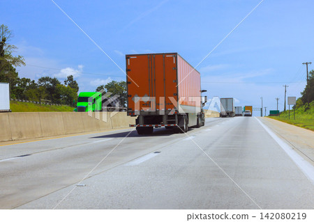 Trucks move along American interstate highway surrounded by green fields. Trucks move along American interstate highway surrounded by green fields. 142080219