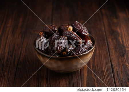 Fresh Ripe Dates in Ceramic Bowl on Dark Wooden Table Serving Healthy Natural Fruit Food Ingredient Fresh Ripe Dates in Ceramic Bowl on Dark Wooden Table Serving Healthy Natural Fruit Food Ingredient 142080264