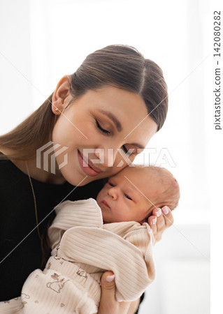 A tender moment between a mother and her newborn baby, showcasing love and connection in a gentle embrace 142080282