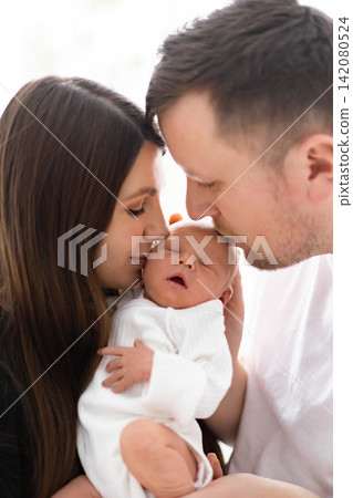 A mother and father tenderly embrace their newborn baby, sharing a moment of pure love and connection A mother and father tenderly embrace their newborn baby, sharing a moment of pure love and connection 142080524