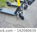 Electric Scooter Parked on Asphalt Sidewalk Close Up  142080630