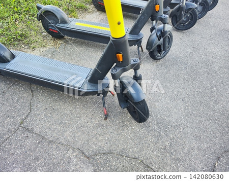 Electric Scooter Parked on Asphalt Sidewalk Close Up Electric Scooter Parked on Asphalt Sidewalk Close Up 142080630
