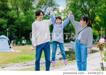 family playing together in the park family playing together in the park 142081672