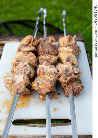 Marinated Meat Skewers Ready for Grilling on Garden Picnic Table Marinated Meat Skewers Ready for Grilling on Garden Picnic Table 142081740