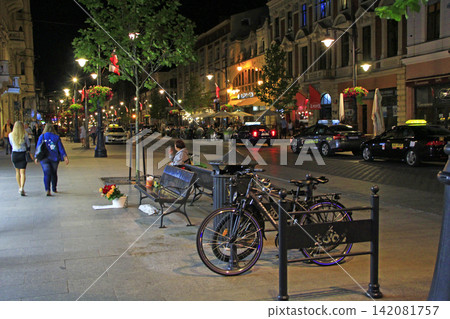 Urban transport. Illumination on night street. Private bicycles Urban transport. Illumination on night street. Private bicycles 142081757