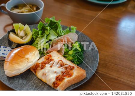A well-balanced breakfast plate placed on a wooden table in a cafe. 142081830