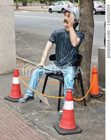 Cordoba, Argentina - April 11, 2026: Seated human figure sculpture beside a food kiosk near Sarmiento Park Cordoba, Argentina - April 11, 2026: Seated human figure sculpture beside a food kiosk near Sarmiento Park 142082004