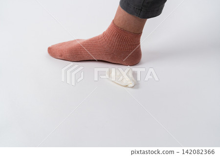 A small sock placed next to one foot A small sock placed next to one foot 142082366