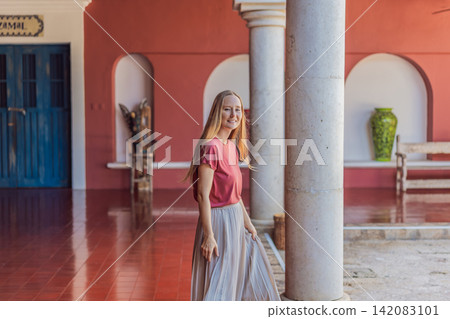 Female tourist walks and twirls through colonial arches, tiled floors and stone details, showing Mexico travel, culture and elegant vacation style concept Female tourist walks and twirls through colonial arches, tiled floors and stone details, showing Mexico travel, culture and elegant vacation style concept 142083101