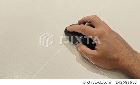 Hand Using a Computer Mouse on a White Surface Hand Using a Computer Mouse on a White Surface 142083616