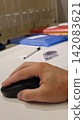 Close-up of a Hand Using Computer Mouse at Workspace 142083621