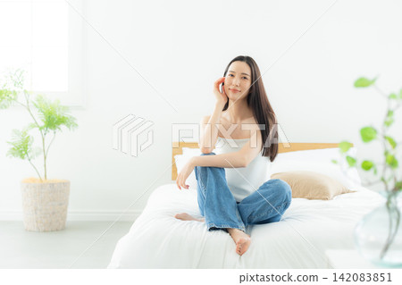 A woman relaxing in the bedroom A woman relaxing in the bedroom 142083851